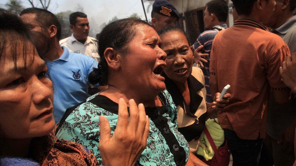 Relative of one of the victim of the crashed military airplane cries as she is comforted near the crash site in Medan, North Sumatra, Indonesia, 30 June 2015.