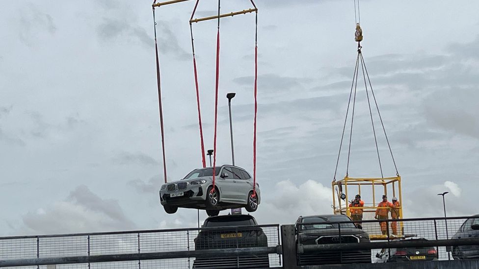 cars being removed on a crane