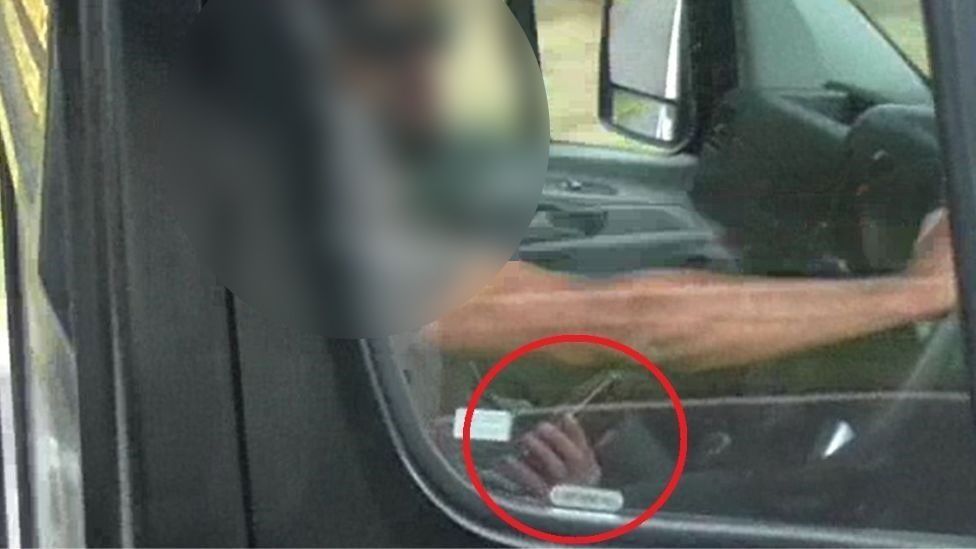 Driver using mobile phone on motorway