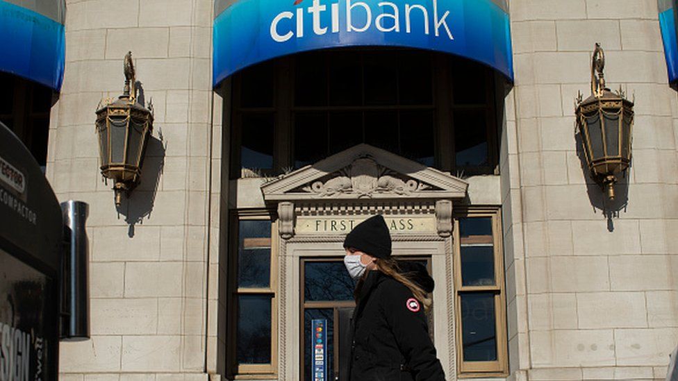 A woman walks past a branch of Citibank in the Financial district in New York in February