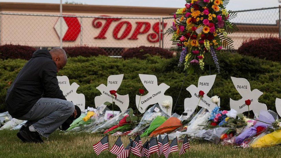 People pray at a memorial at the scene of a weekend shooting at a Tops supermarket in Buffalo, New York, U.S. May 20, 2022.