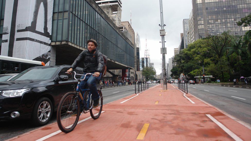 A man on a bicycle tries out the new cycle lane on Paulista Avenue