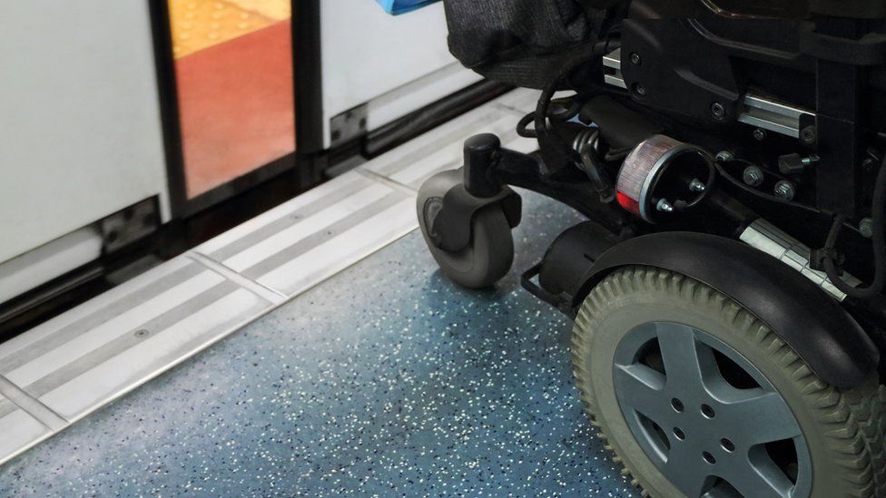 Wheelchair on a platform in front of a train with doors partially opened