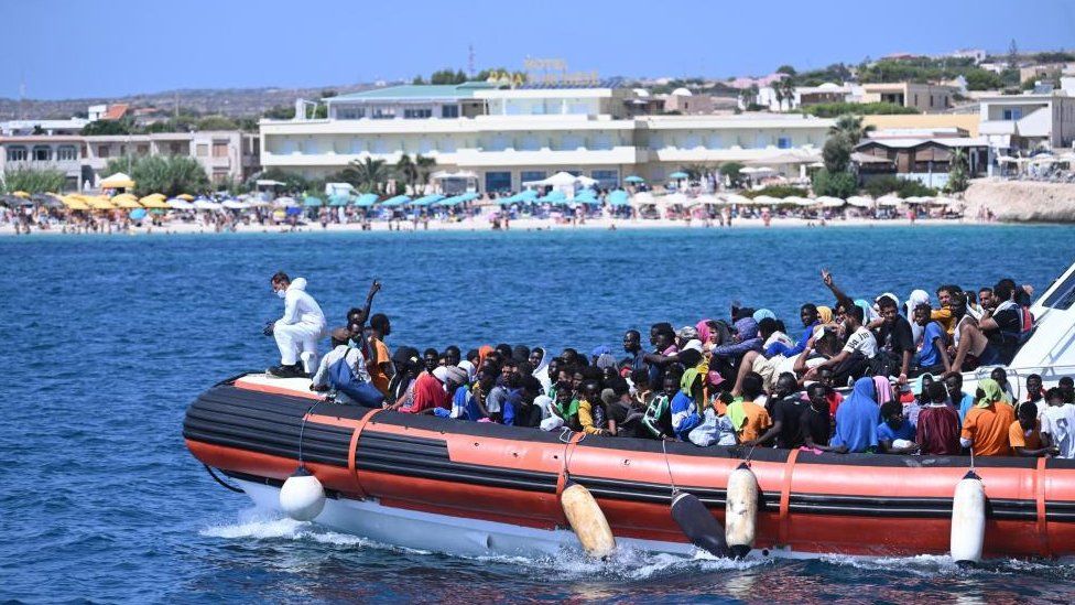 Некоторых мигрантов везут на лодке на борт парома «Галактика», который направится в сторону Порто-Эмпедокле, Лампедуза, южная Италия, 15 сентября 2023 г.