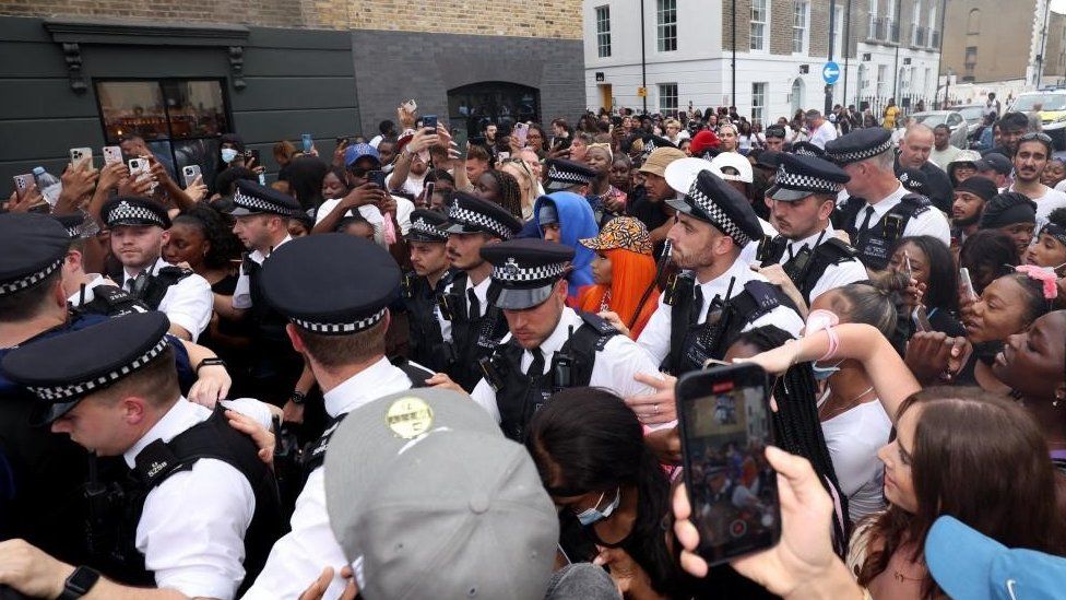 Police surround American rapper Nicki Minaj as fans attend a meet and greet at Camden's Cafe Koko