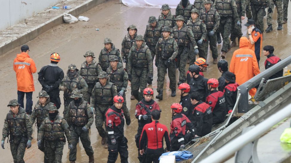 A group of soldiers enter a flooded underground tunnel in the town of Osong, North Chungcheong Province, central South Korea, on 17 July 2023, to join the search operation for missing people who are believed to have been submerged inside the tunnel after a nearby river overflowed due to heavy rain on 15 July.