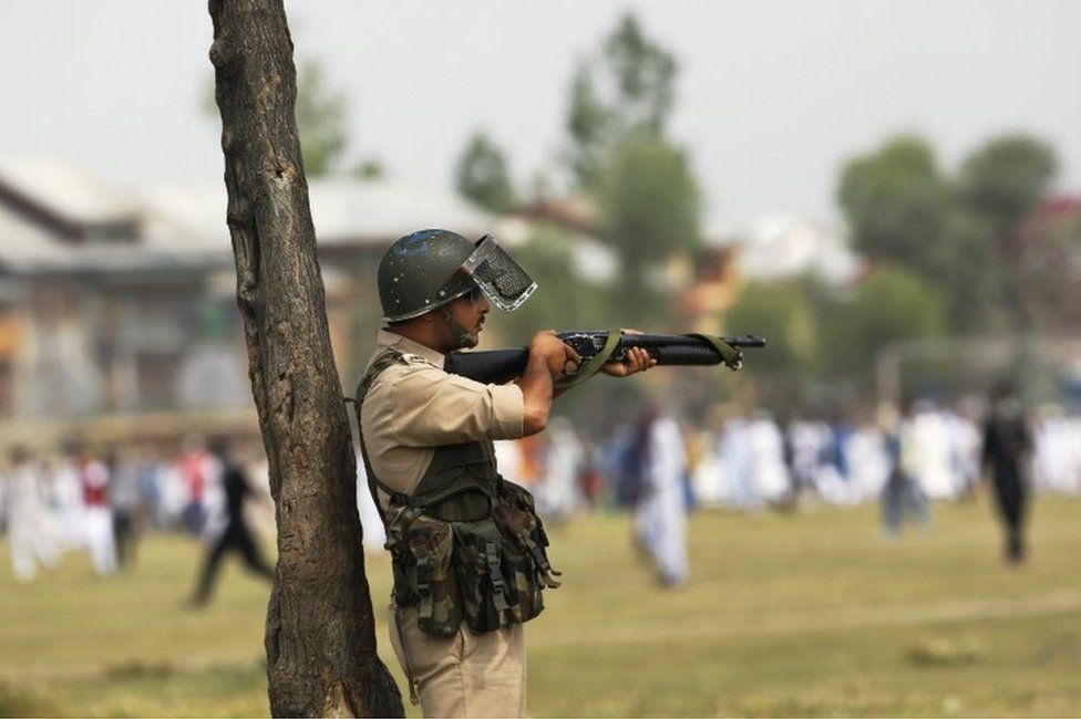 An Indian policeman aim his pellet gun at protesters during a protest in Srinagar, Indian controlled Kashmir, Wednesday, July 6, 2016