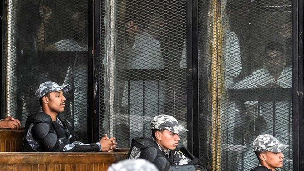 Members of Egypt"s banned Muslim Brotherhood are seen inside a glass dock during their trial in the capital Cairo on July 28, 2018.
