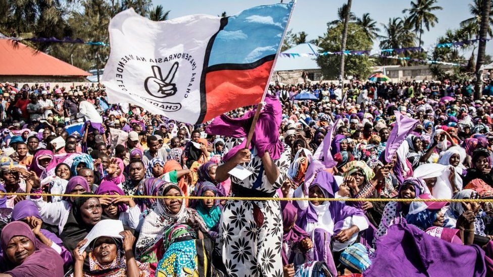 A women waves a flag of the Zanzibar opposition party, the Party for Democracy and Progress commonly known as Chadema, during a rally of opposition party Alliance for Change and Transparency (ACT) in Nungwi, on October 24, 2020.