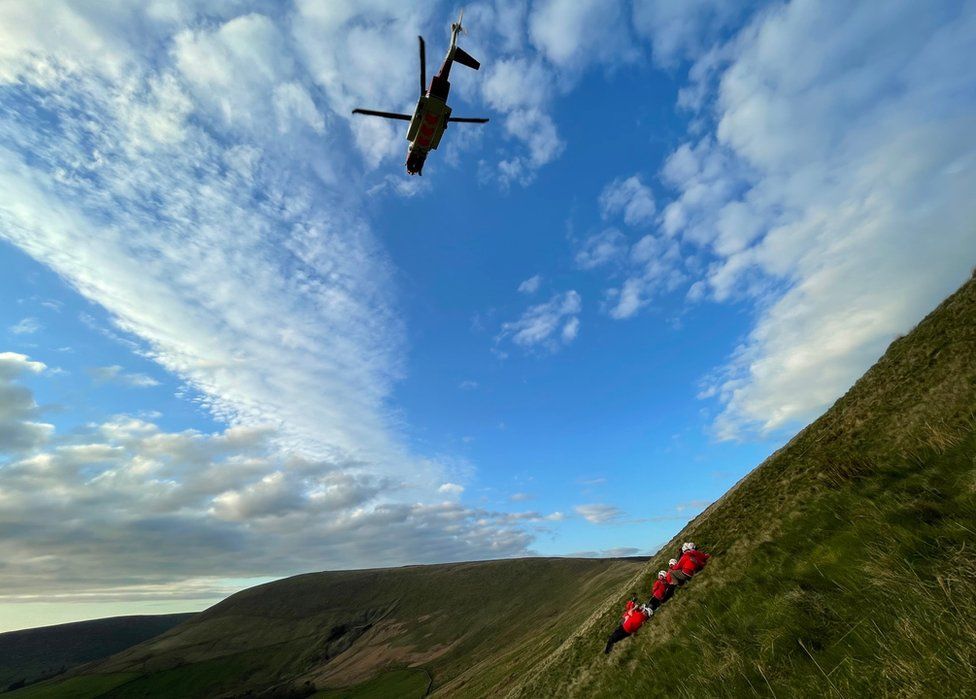 Helicopter above a mountain rescue team