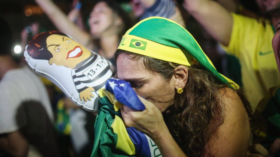 A pro-impeachment demonstrator kisses a Brazilian flag in Rio de Janeiro, 17 April