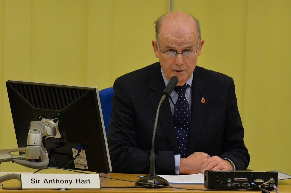 Sir Anthony Hart sits at a desk during the Historical Institutional Abuse Inquiry