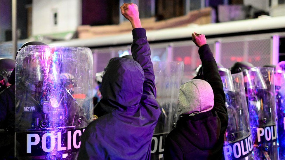 Demonstrators raise their fists in front of police officers during a rally after the death of Walter Wallace Jr., a Black man who was shot by police in Philadelphia, Pennsylvania, US, 27 October, 2020.