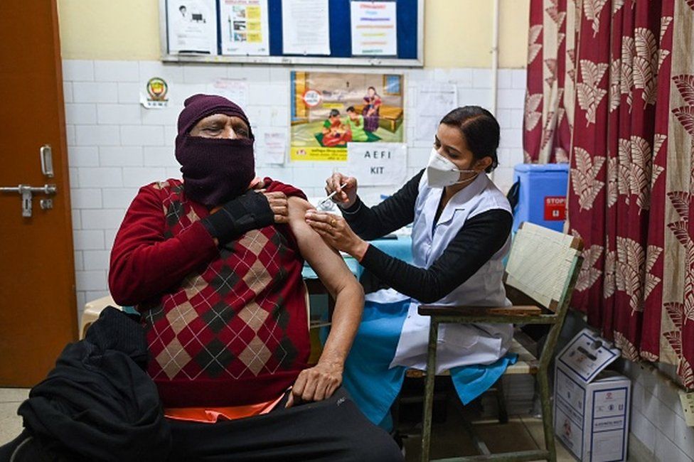 A health worker inoculates a man with a third dose of the Covaxin vaccine at a vaccination center in New Delhi on January 10, 2022, as the country sees an Omicron-driven surge in Covid-19 coronavirus cases