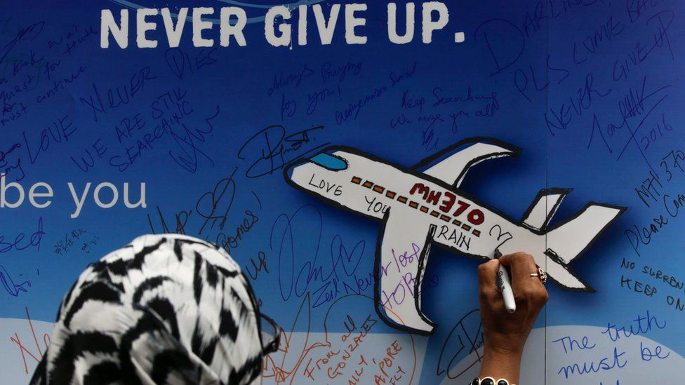 A file picture dated 06 March 2016 shows a woman writing messages for the passengers of missing Malaysia Airlines flight MH370 on a banner during a remembrance ceremony to mark the second anniversary of the plane"s disappearance, in Kuala Lumpur, Malaysia