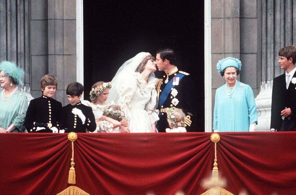 Prince Charles And Princess Diana kissing on The balcony of Buckingham Palace, 29 July 1981. They are surrounded by their bridesmaids and pageboys as well as Queen Elizabeth II, Prince Edward and the Queen Mother.