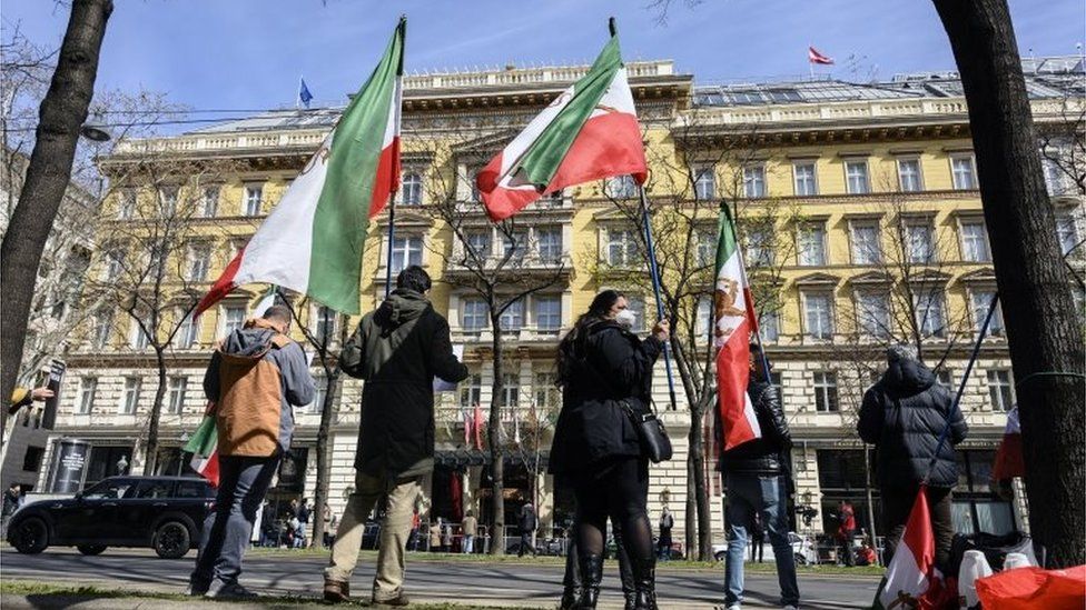 Supporters of an Iranian opposition group wave flags outside hotel where talks are taking place in Vienna (09/04/21)