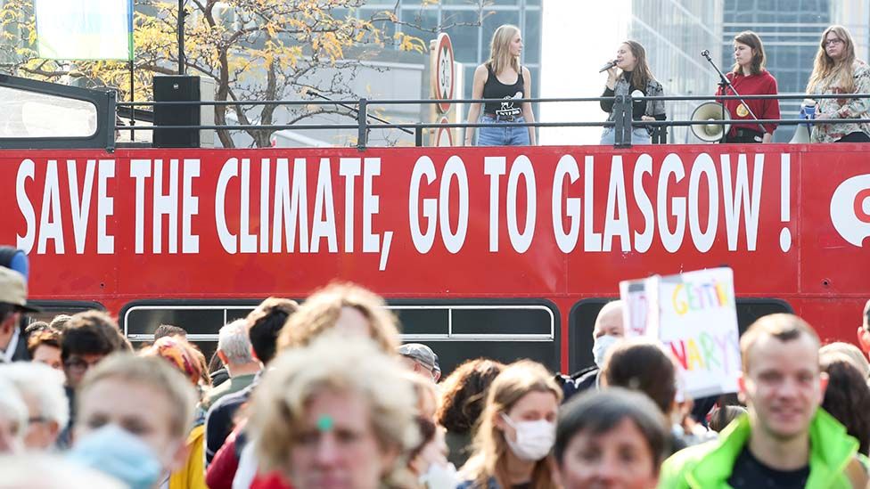 People take part in a climate march in Brussels ahead of the COP26 climate summit