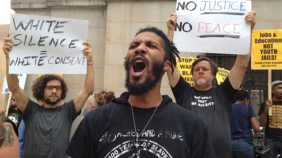 Protesters gather outside Baltimore Circuit Court, as the first court hearing was set to begin in the case of six police officers criminally charged in the death of Freddie Gray, on on 2 September 2015 in Baltimore