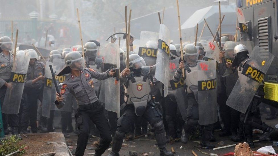 Police are seen during clashes outside parliament in Jakarta