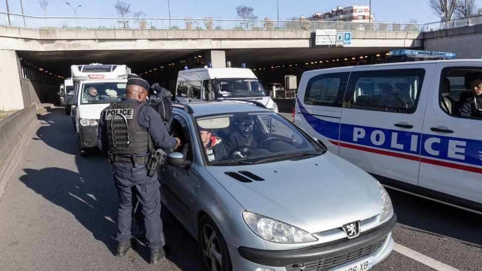 Police issue a driver with a fine as they try to stop a convoy from entering Paris, 12 Feb 2022