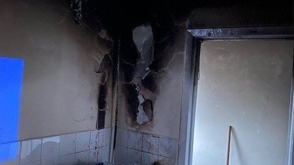 A fire ravaged wall in a kitchen