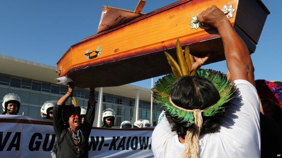 Indians of the Guarani Kaiowa tribe lift a coffin during a protest against the murder of indigenous leader Simao Vilhalva, in front of the Planalto Presidential Palace, in Brasilia, Brazil, Tuesday, Sep. 1, 2015.