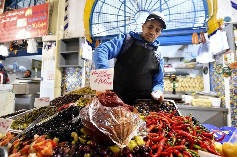 A shopkeeper doles out freshly made harissa.
