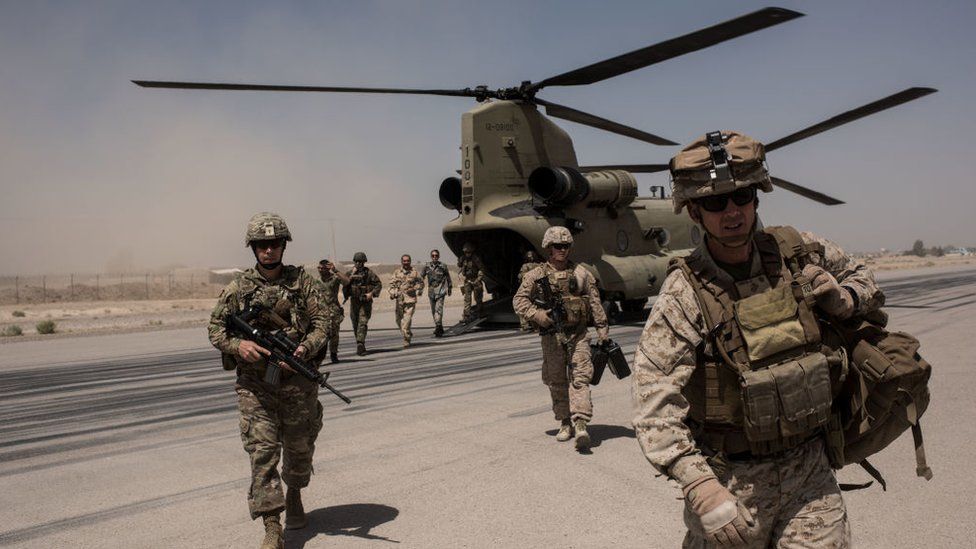 .S. service members walk off a helicopter on the runway at Camp Bost on September 11, 2017 in Helmand Province, Afghanistan.