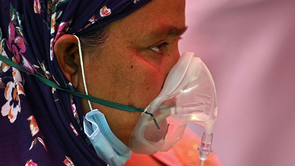Woman in an oxygen mask in India