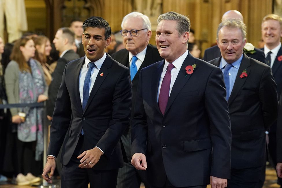 Prime Minister Rishi Sunak (left) and Labour Party leader Sir Keir Starmer walk through the Members' Lobby at the Palace of Westminster ahead of the State Opening of Parliament in the House of Lords, London.