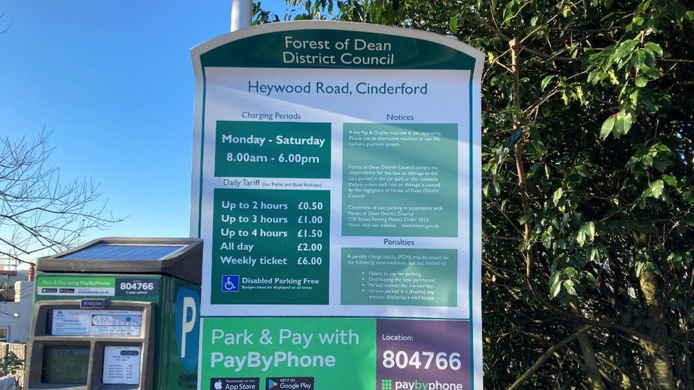 Forest of Dean District Council sign at Haywood Car Park detailing previous parking charges
