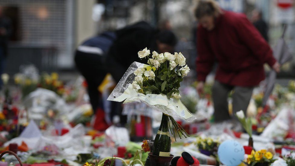 People tend to tributes in the Place de la Bourse in Brussels, 28 March
