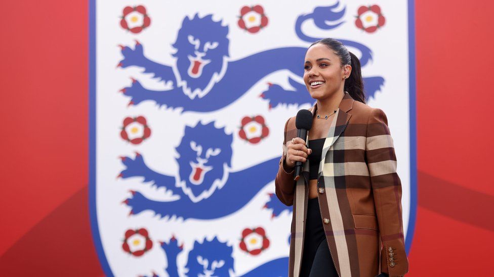 Former England player Alex Scott stands in front of the England football logo
