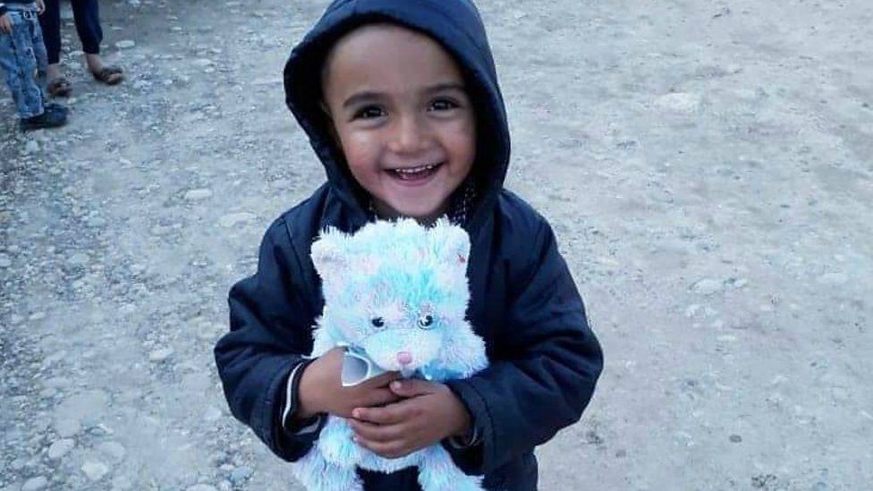 A smiling child with his new teddy