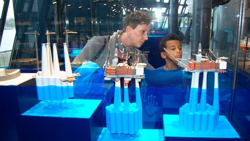 A woman shows an oil platform miniature replica to a child in Stavanger's oil museum
