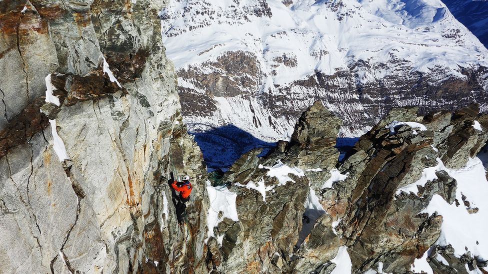 A researchers install sensors on rocks of Mount Matterhorn in the Alps