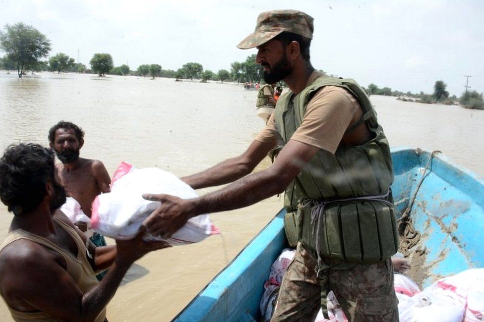 Pakistani Army soldiers distribute food to flood-affected people in Rajanpur District, Punjab province, Pakistan, 27 August 2022