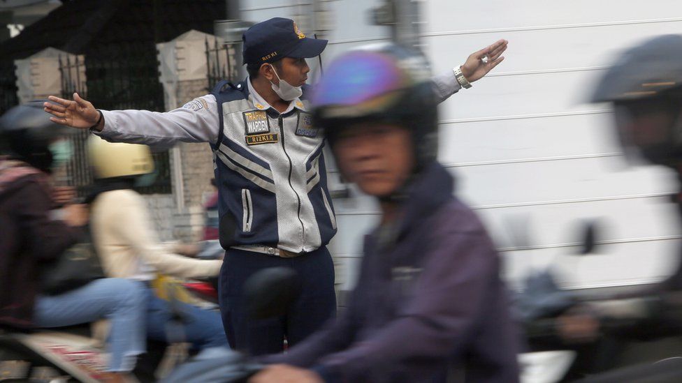 An Indonesian traffic officer directs traffic in Jakarta