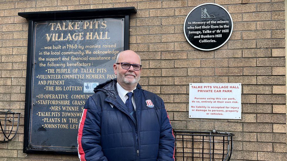 Man standing in front of a plaque