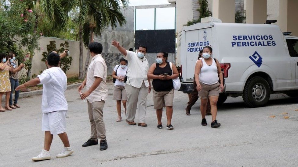 Hotel workers are seen at the entrance to a hotel after two suspected drug gang members were shot dead