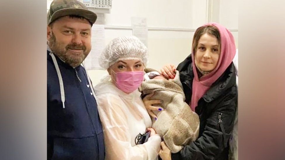 Dmitry and Anna Litvinov with a medical professional holding the baby