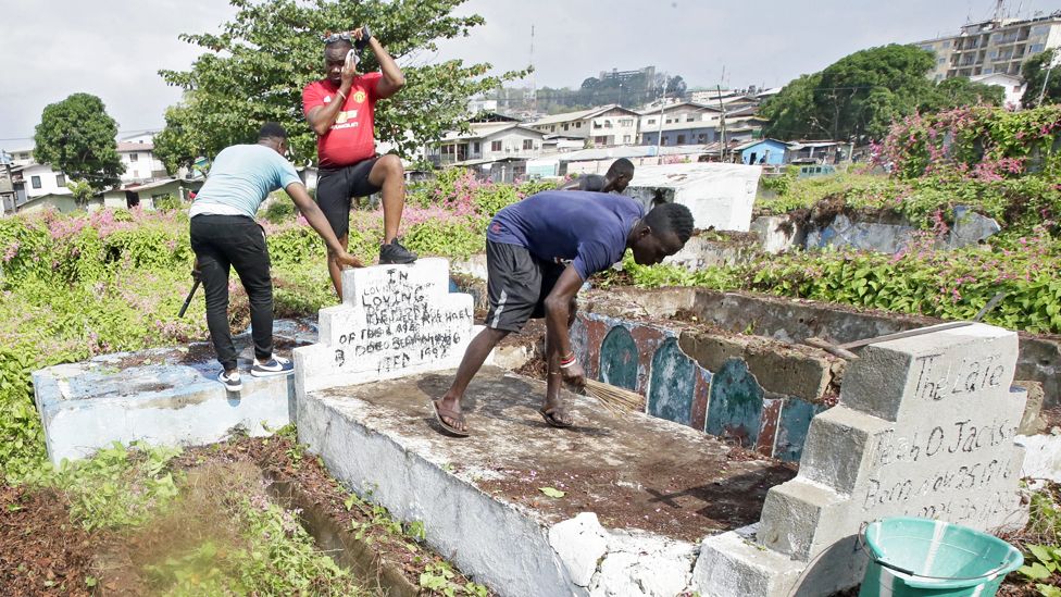 Men cleaning graves at Palm Groove Cemetery in Monrovia, Liberia - Wednesday 11 March 2020