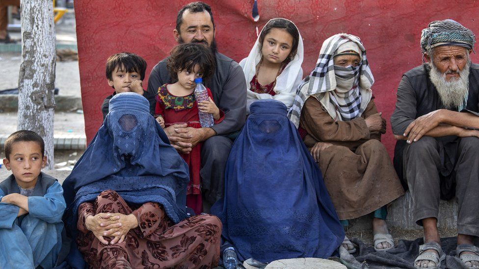 Charyar,70, from the Balkh province sits alongside his family at a makeshift IDP camp in Share-e-Naw park