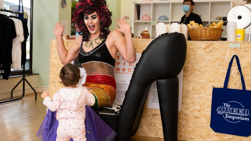 Aida H Dee The Storytime Drag Queen reading to children in a library.