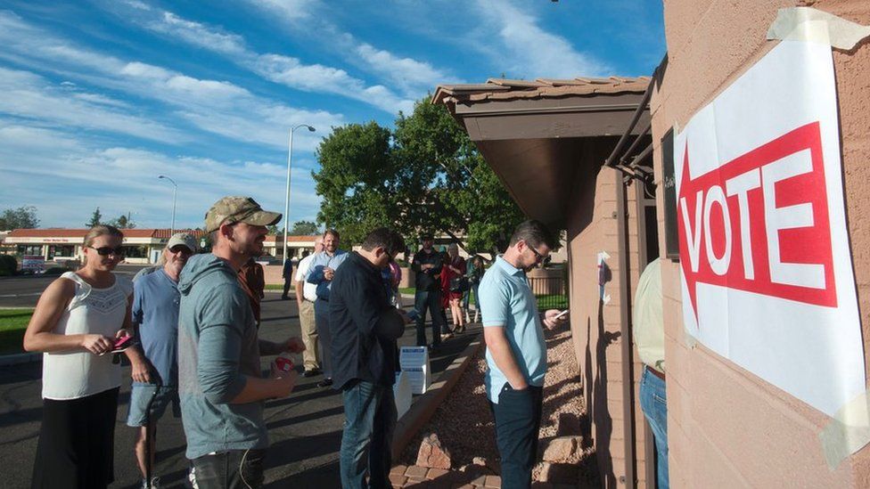 Voters wait in line in front of a polling station to cast their ballots in the US presidential election in Scottsdale, Arizona on 8 November 2016