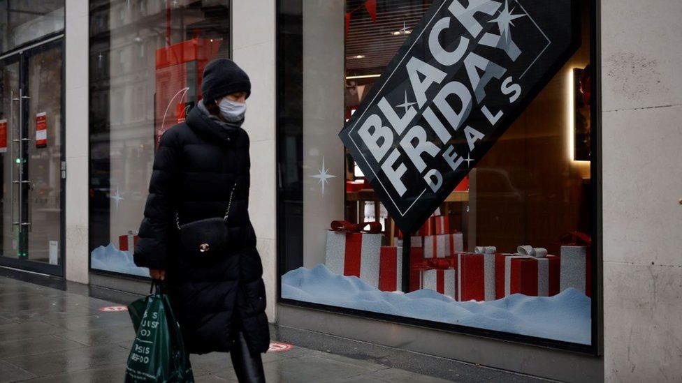 Shopper walks past Black Friday deal sign