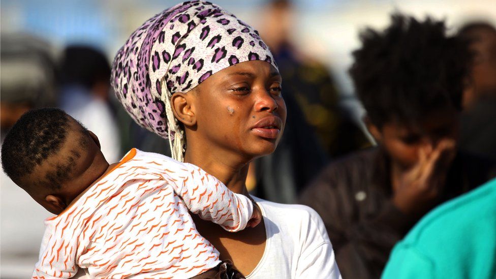 A woman cries as illegal migrants of different African nationalities arrive at a naval base in the capital Tripoli on May 6, 2018, after they were rescued from inflatable boat off the coast of Al-Zawiyah.