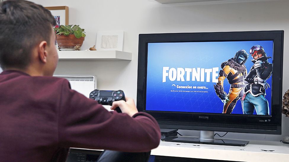 Boy playing fortnite on computer