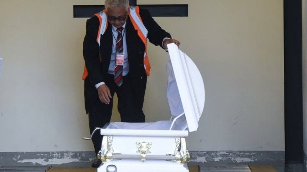 An official looks at the coffin containing the body of Jakelin Caal in Guatemala City. Photo: 23 December 2018